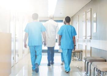 Три врача идут по коридору центра реабилитации алкоголиков